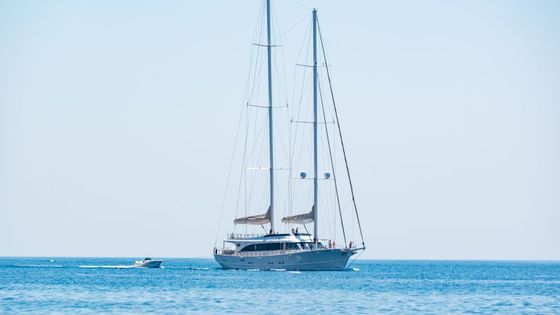 Elegant sailing yacht cruising on the calm blue waters under a clear sky.