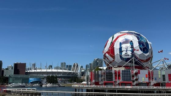 View of Vancouver's Science World featuring FIFA display and BC Place Stadium under a clear blue sky.